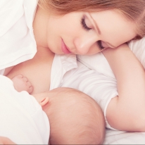 mother feeding breast her baby in the bed. sleeping together